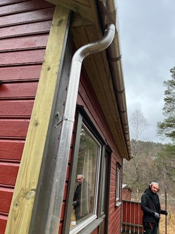 Metal gutter on red cabin wall