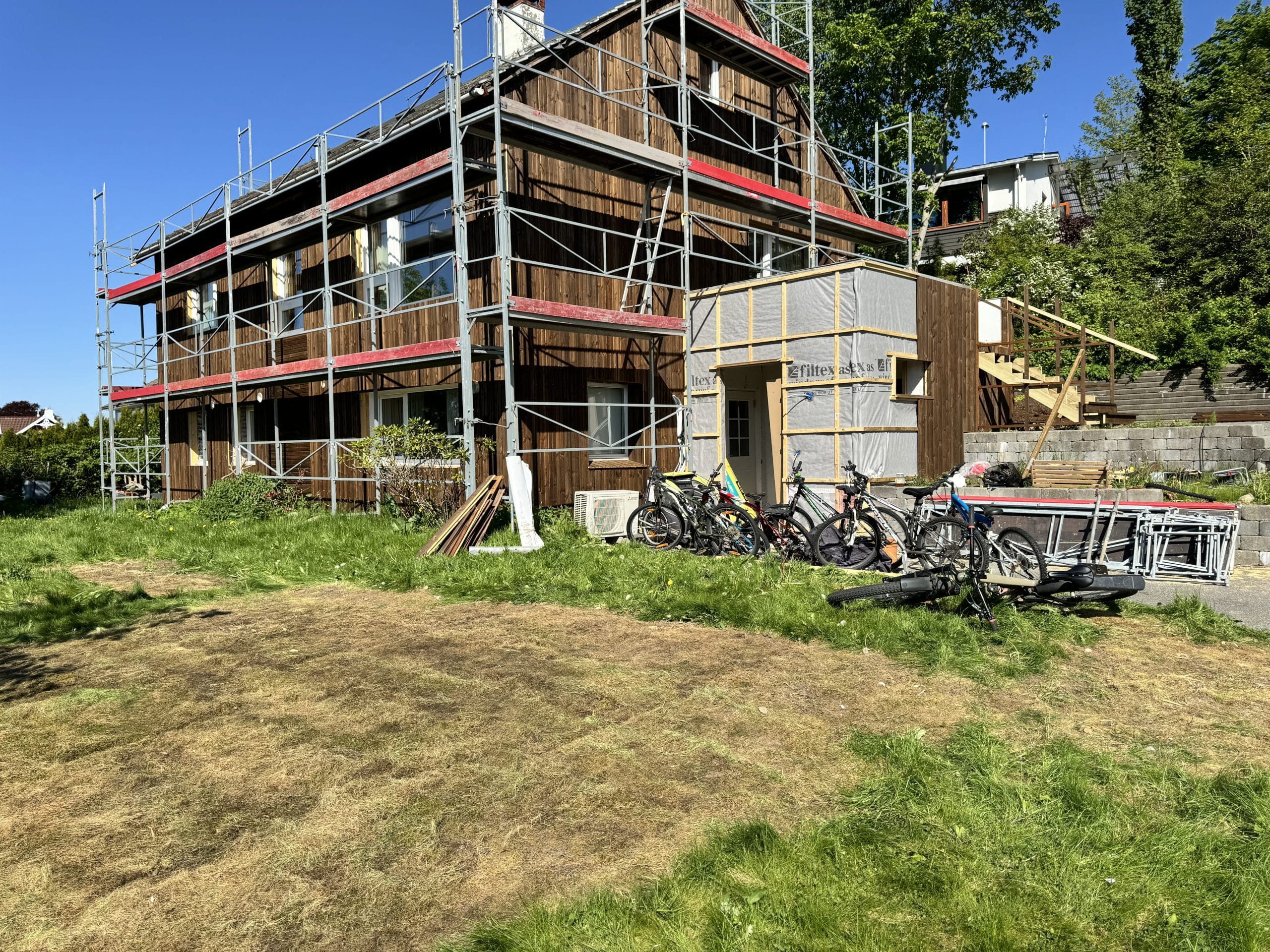 House under construction with bicycles nearby.