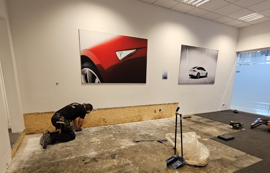 Worker renovating space with car posters